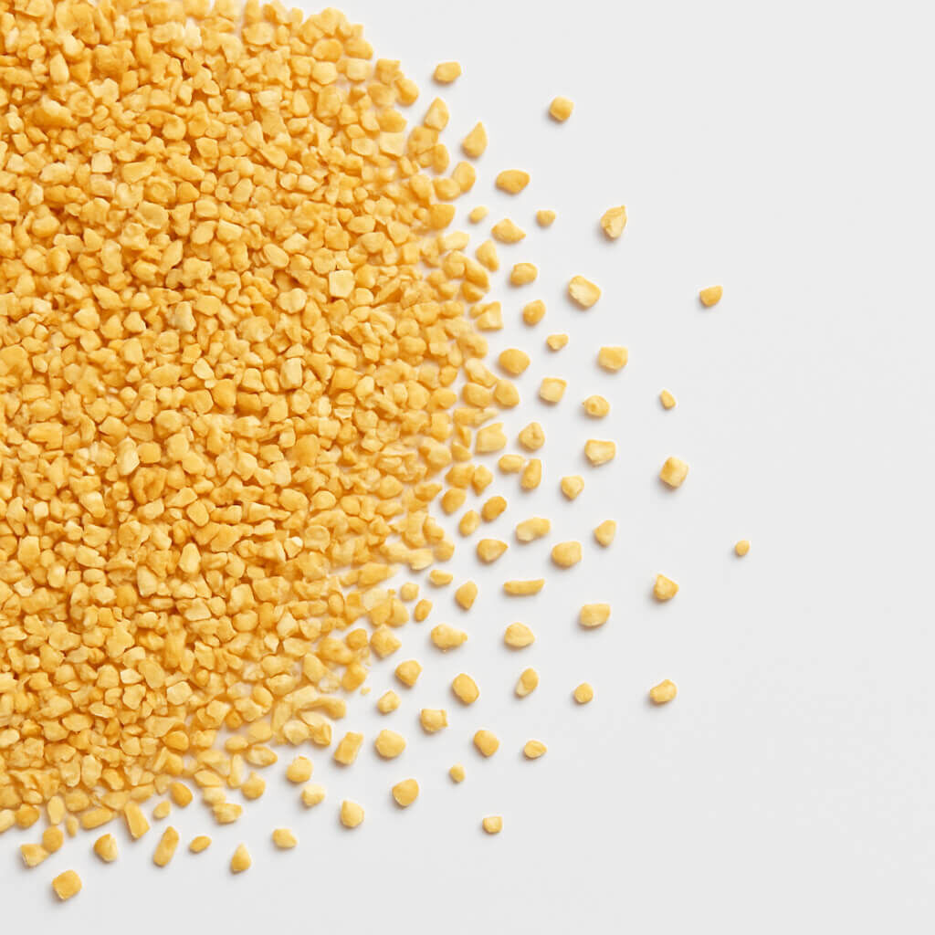 Close-up of yellow polenta granules on white surface