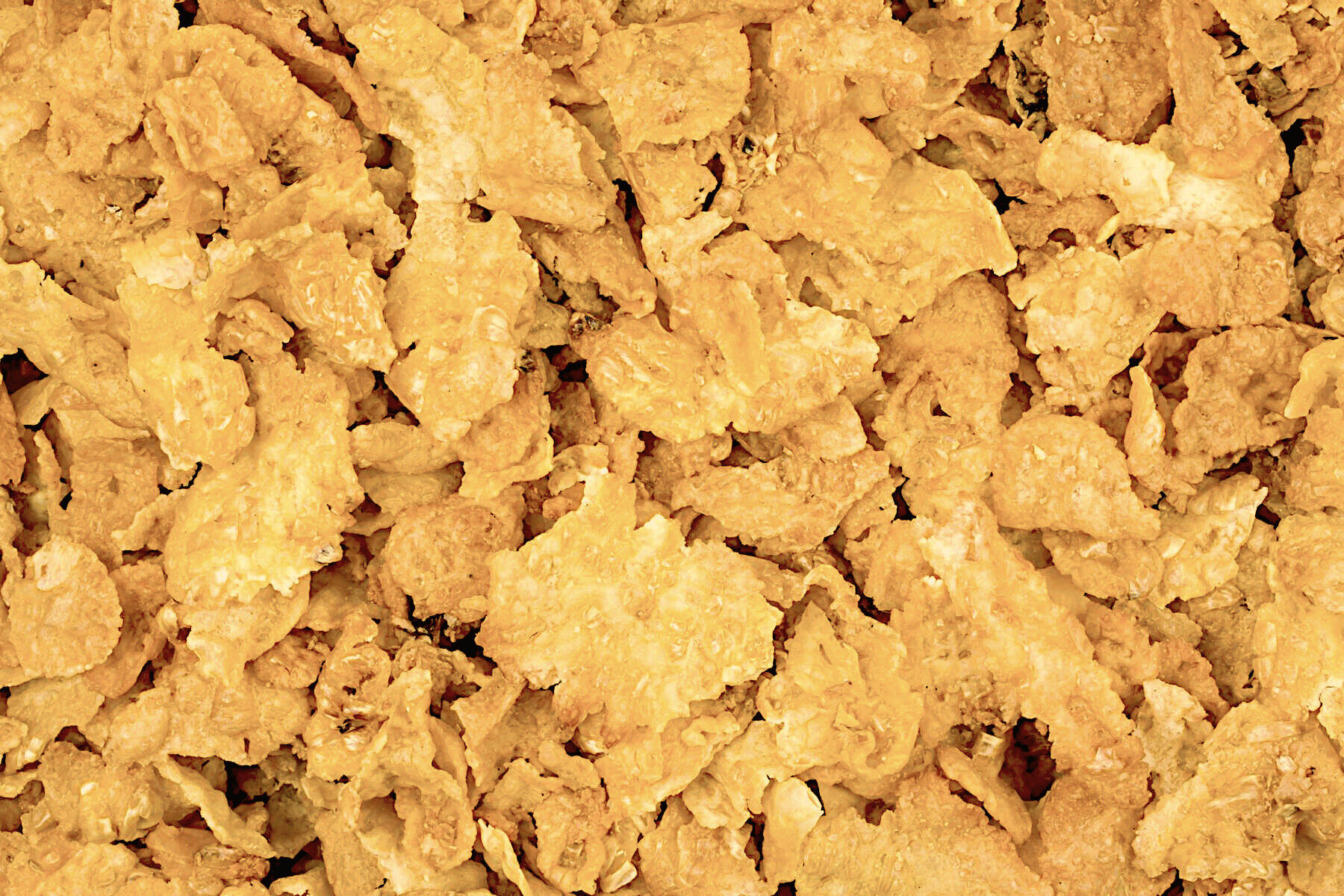Nærbillede af gyldne, sprøde cornflakes spredt i et lag