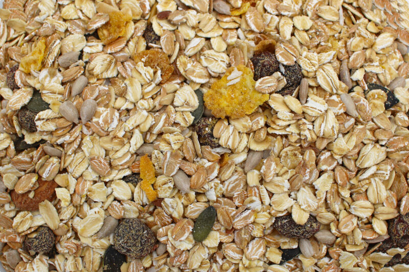 Nahaufnahme von Müsli mit Haferflocken, Rosinen, Cornflakesstücken, Sonnenblumen- und Kürbiskernen