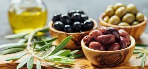 Bowls of mixed olives with olive oil and olive branch