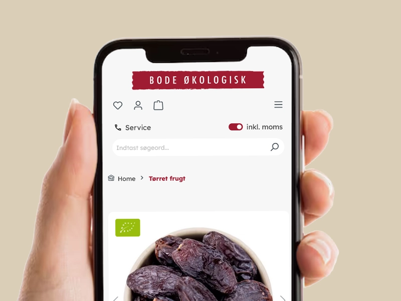 Mobiltelefon med Bode Økologisk webshop vist, nærbillede af økologiske tørrede dadler i en skål