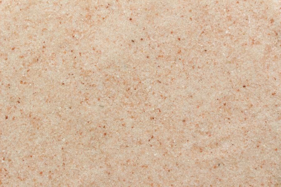 Nærbillede af fint malet Himalayasalt med små rosa og hvide saltkorn og tydelig tekstur