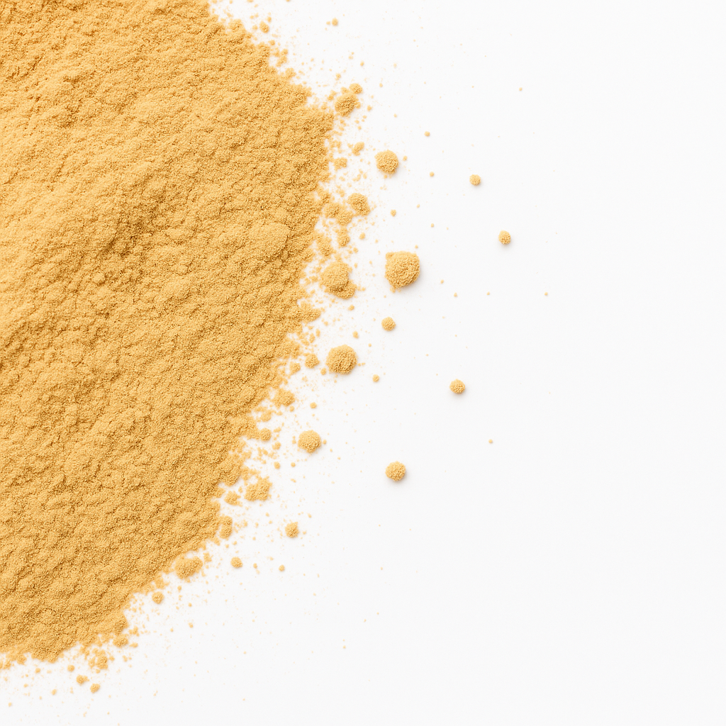 Nærbillede af gult pulver spredt på hvid baggrund med fin, luftig tekstur
