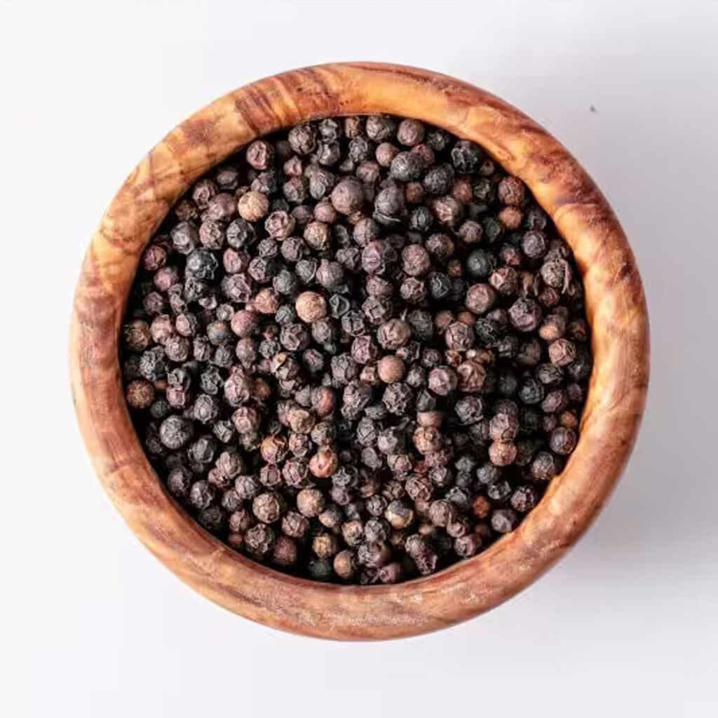 Træskål fyldt med sorte peberkorn, set oppefra