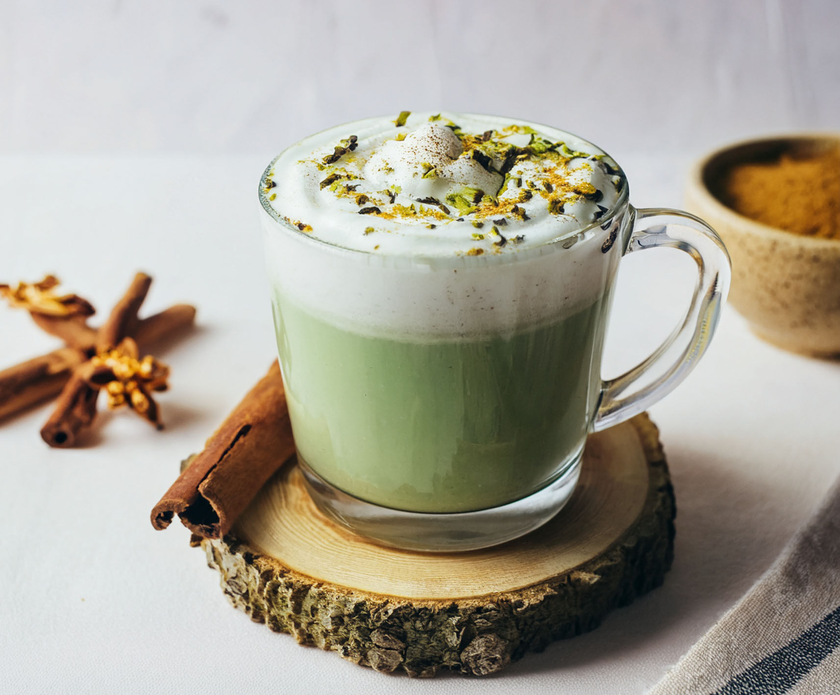 Glass mug of matcha latte topped with whipped foam