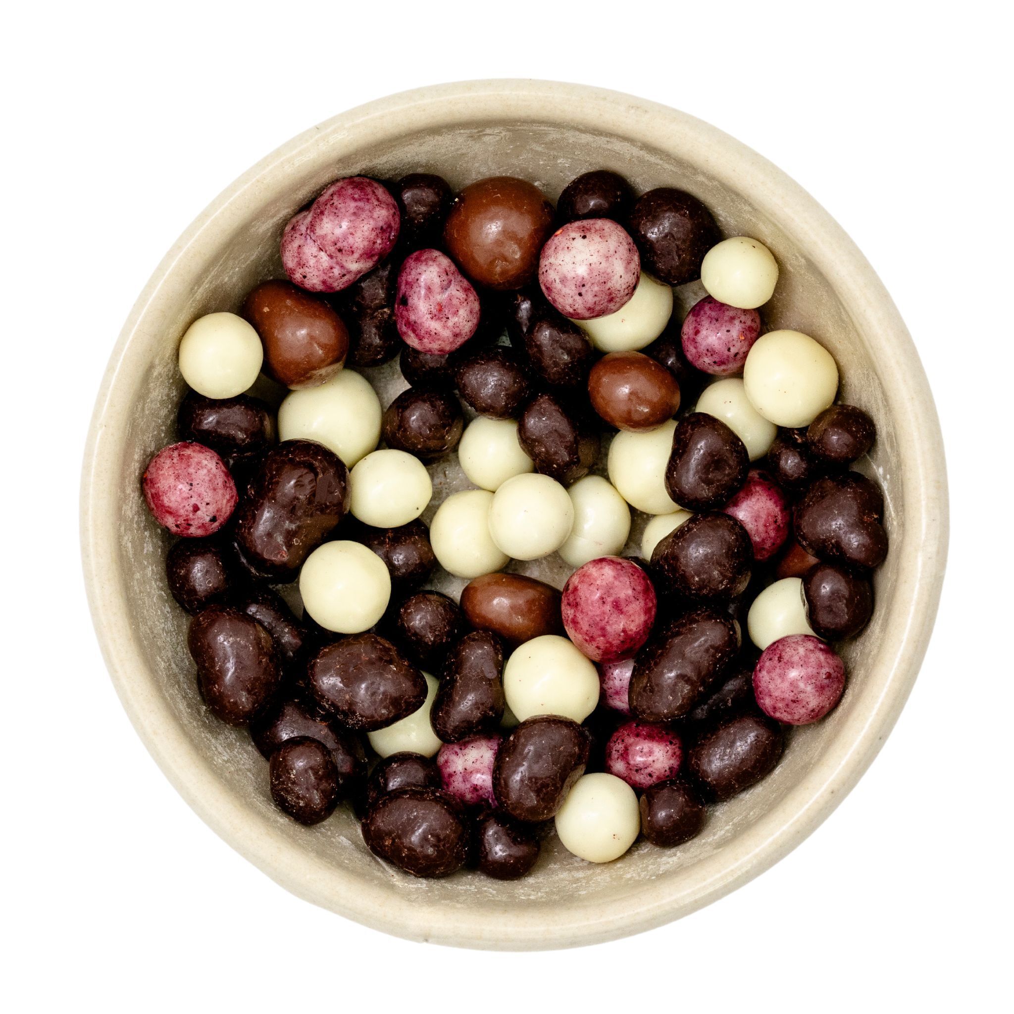 Keramikschale mit gemischten Schokoladen-Dragees aus weißer Schokolade, Milchschokolade und Zartbitterschokolade sowie roten, fruchtüberzogenen Dragees