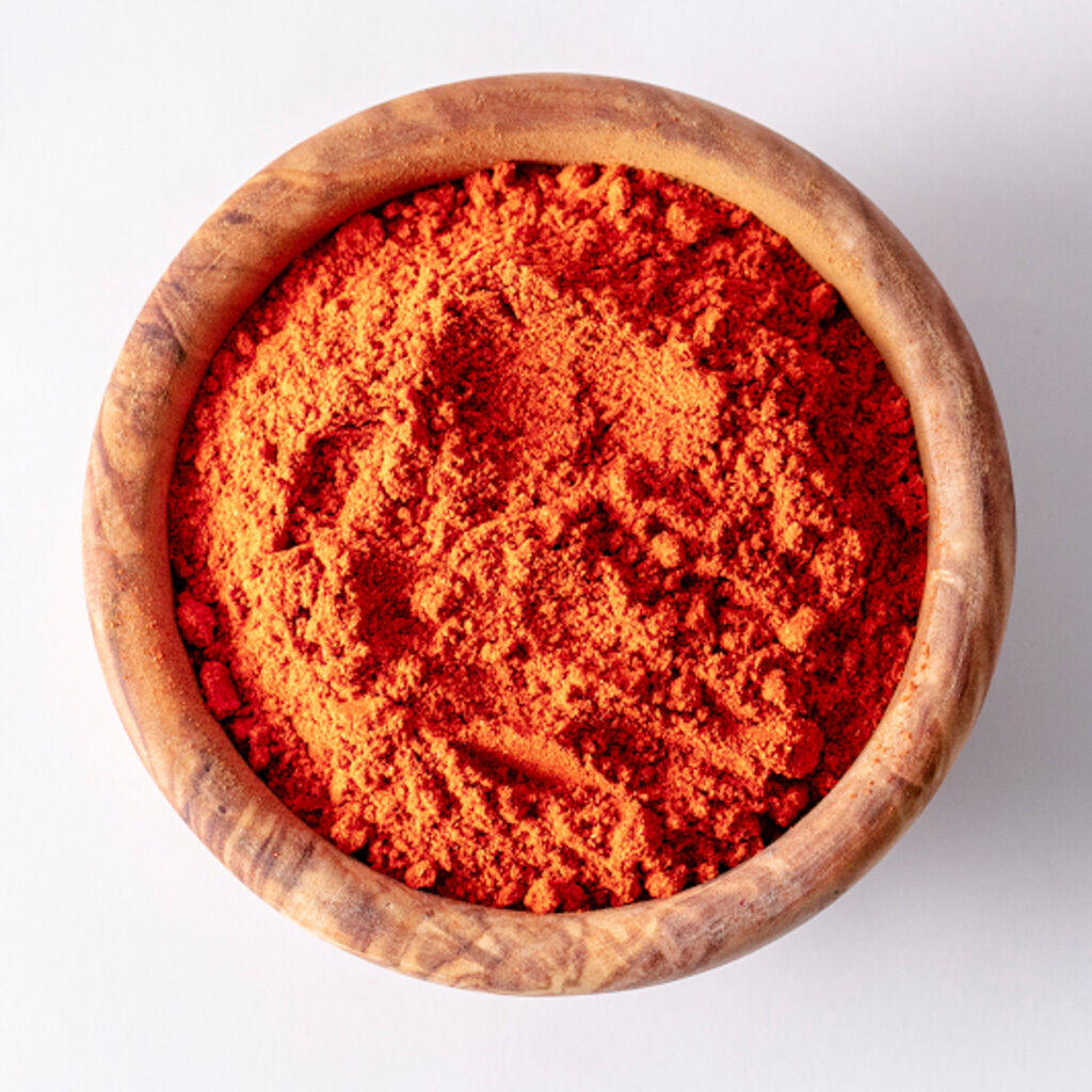 Træskål fyldt med fint rødt paprika-pulver set ovenfra