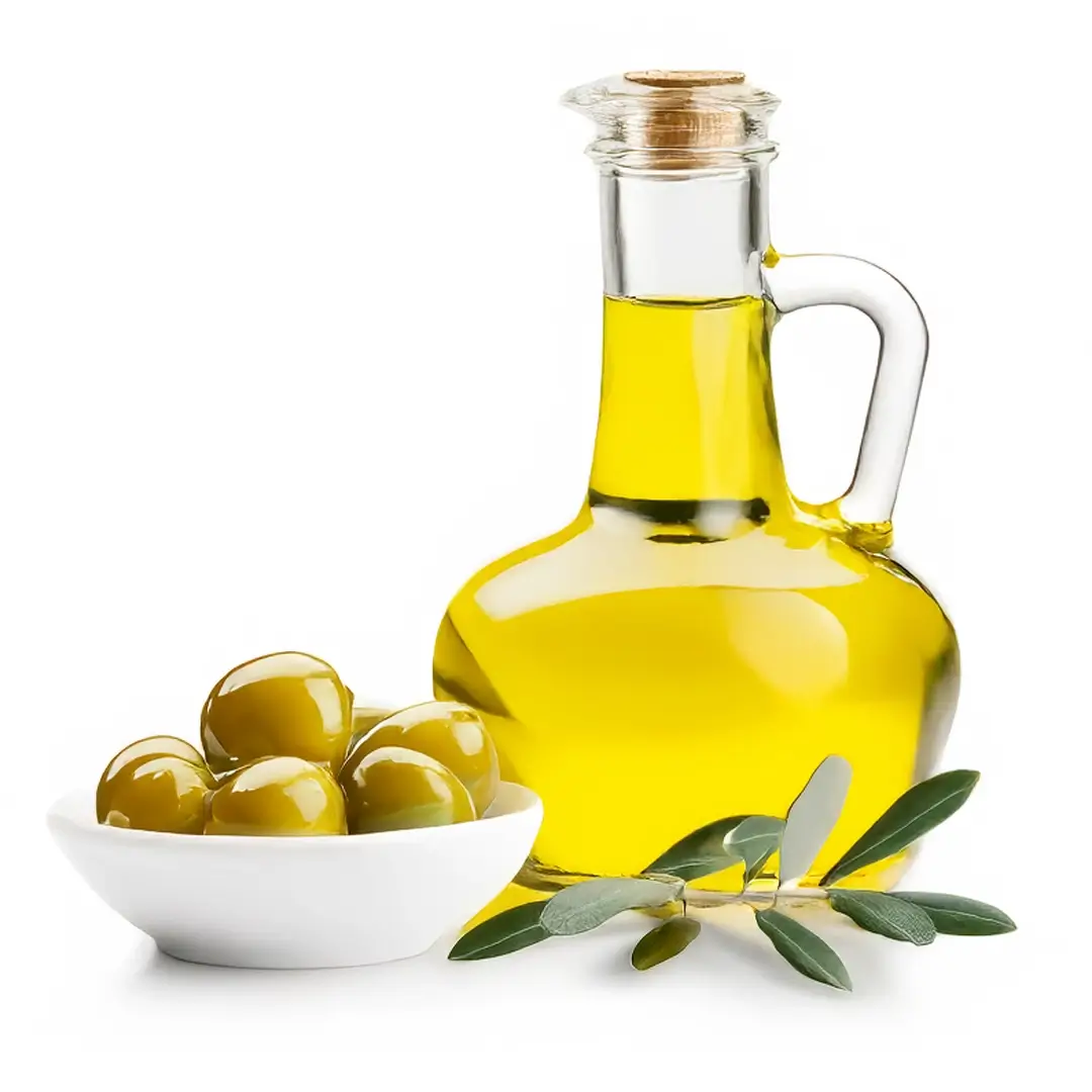 Glaskaraffel med gylden ekstra jomfru olivenolie ved siden af en skål med grønne oliven og en olivenkvist på hvid baggrund
