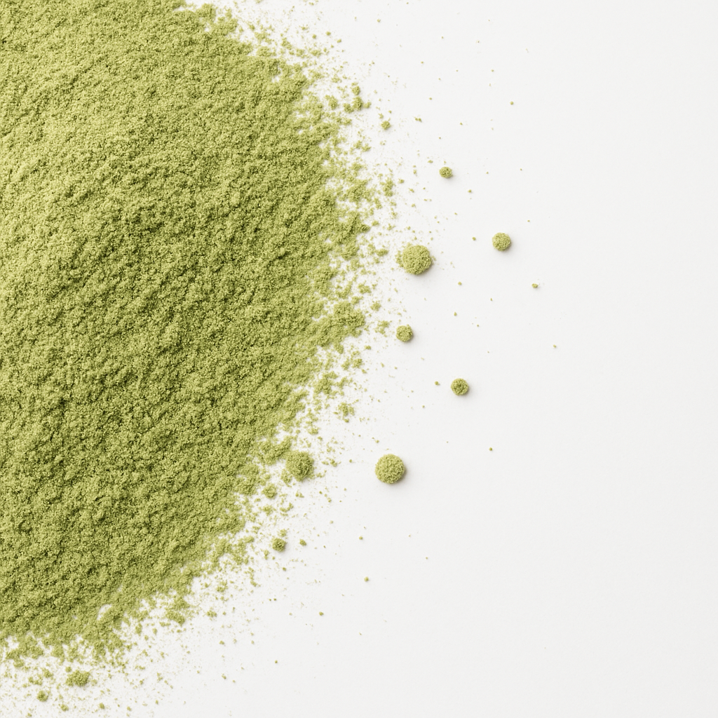 Close-up of fine matcha green tea powder on a white surface, showcasing its vibrant color and texture.