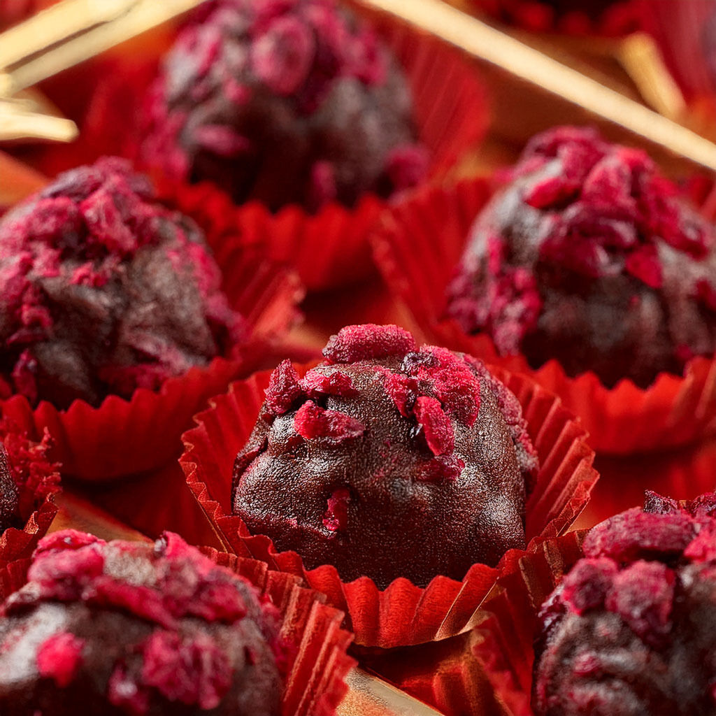 Close-up of dark chocolate truffles with raspberry