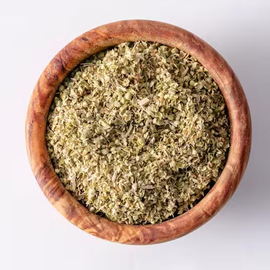 Topvisning af tørret oregano i rund træskål på hvid baggrund