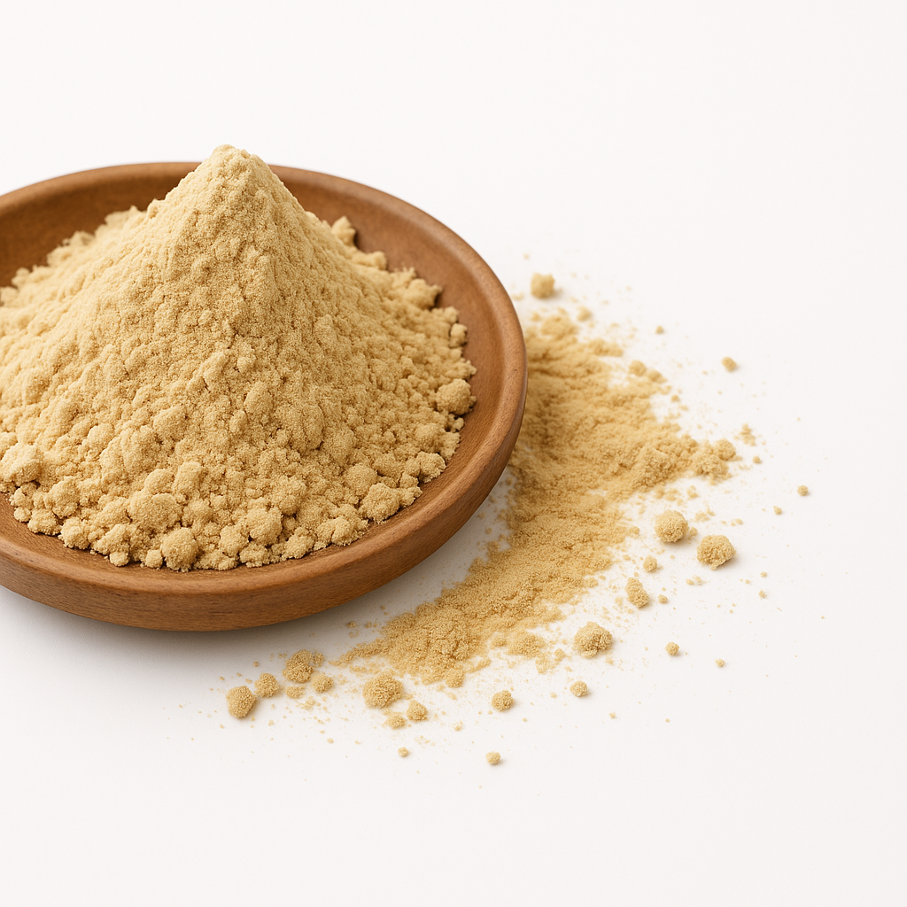 Lyst brunligt pulver i rund træskål på hvid baggrund med lidt pulver spredt udenfor skålen