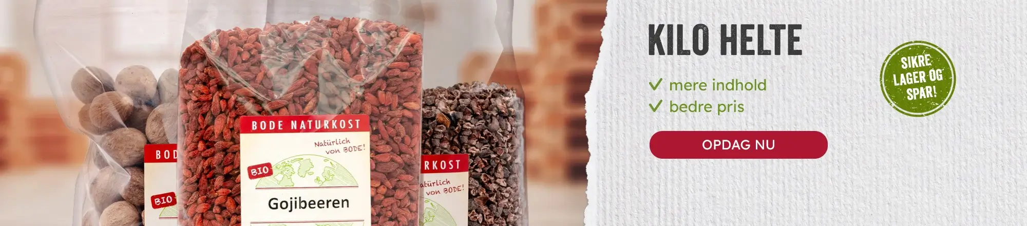 Nærbillede af plastposer med økologiske gojibær og andre tørrede naturprodukter foran reklametekst KILO HELTE med punkter 'mere indhold' og 'bedre pris' samt rød knap med teksten OPDAG NU.