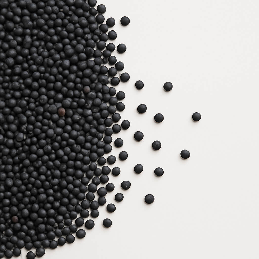 Black spherical pellets scattered on white background