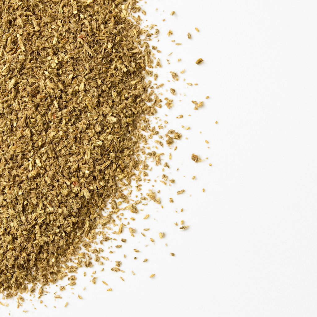 Nærbillede af malede tørrede pizzakrydderier spredt på en hvid baggrund