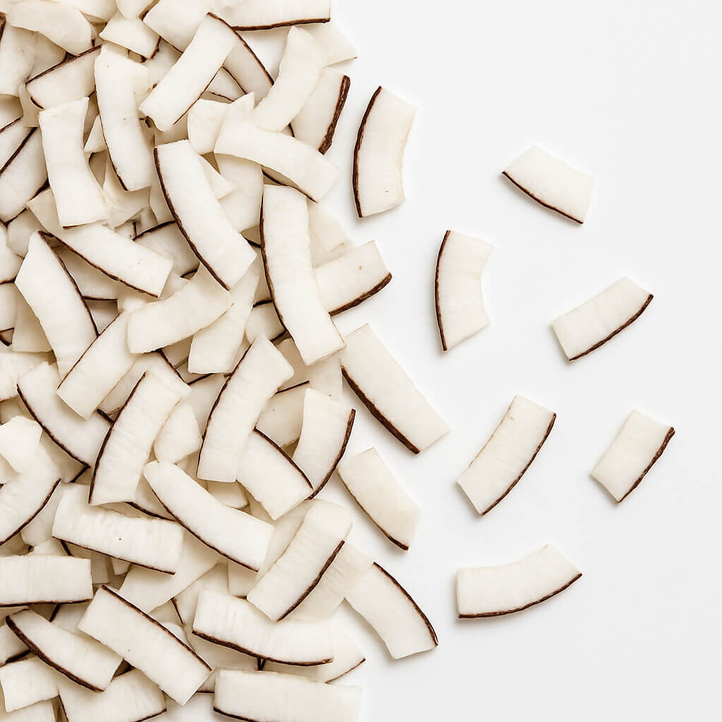 Chopped coconut pieces with brown skin on white background