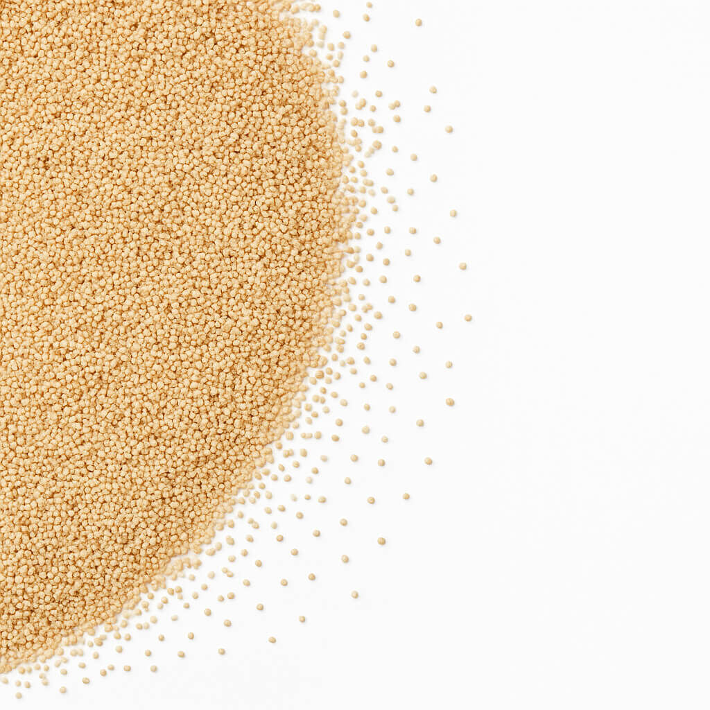 Pile of instant dry yeast granules on white background