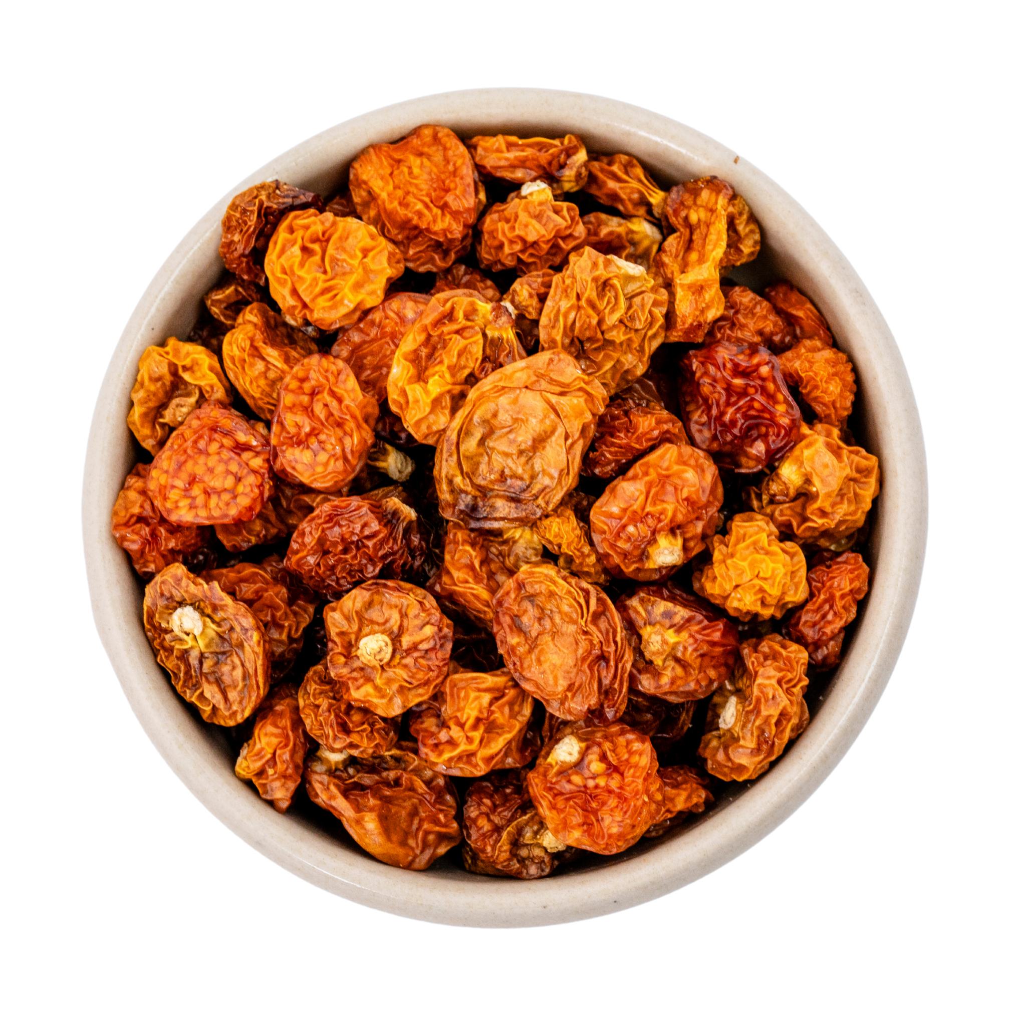 Skål fyldt med tørrede physalisbær (cape gooseberries), orange-gyldne rynkede bær set ovenfra på hvid baggrund
