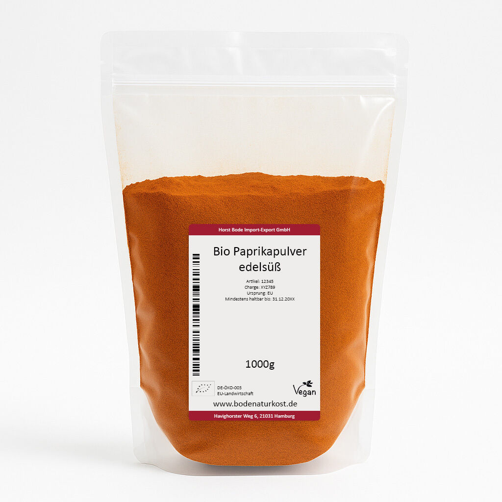 Stående gennemsigtig plastpose med orange-rødt økologisk paprikapulver; hvid etiket med teksten 'Bio Paprikapulver edelsüß' og vægtangivelse 1000 g.