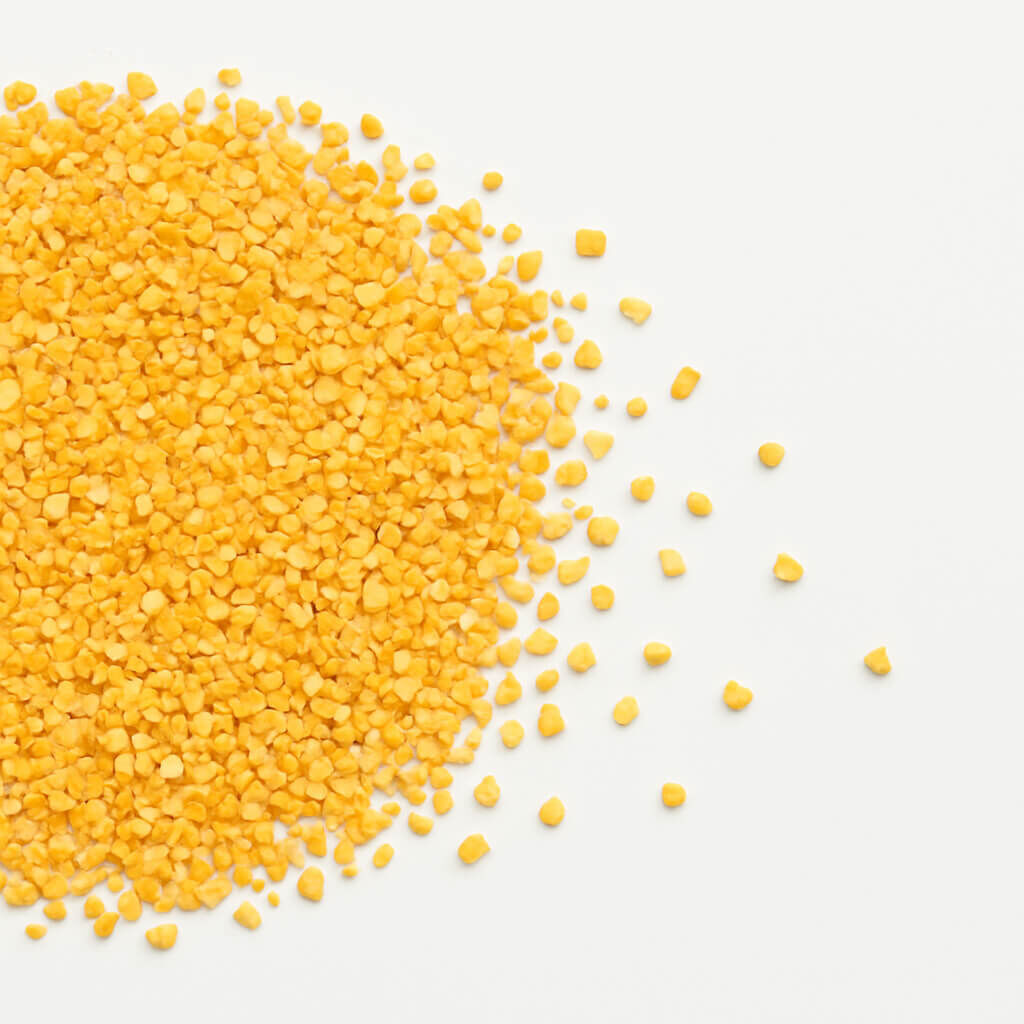 Heap of coarse yellow corn grits on white background