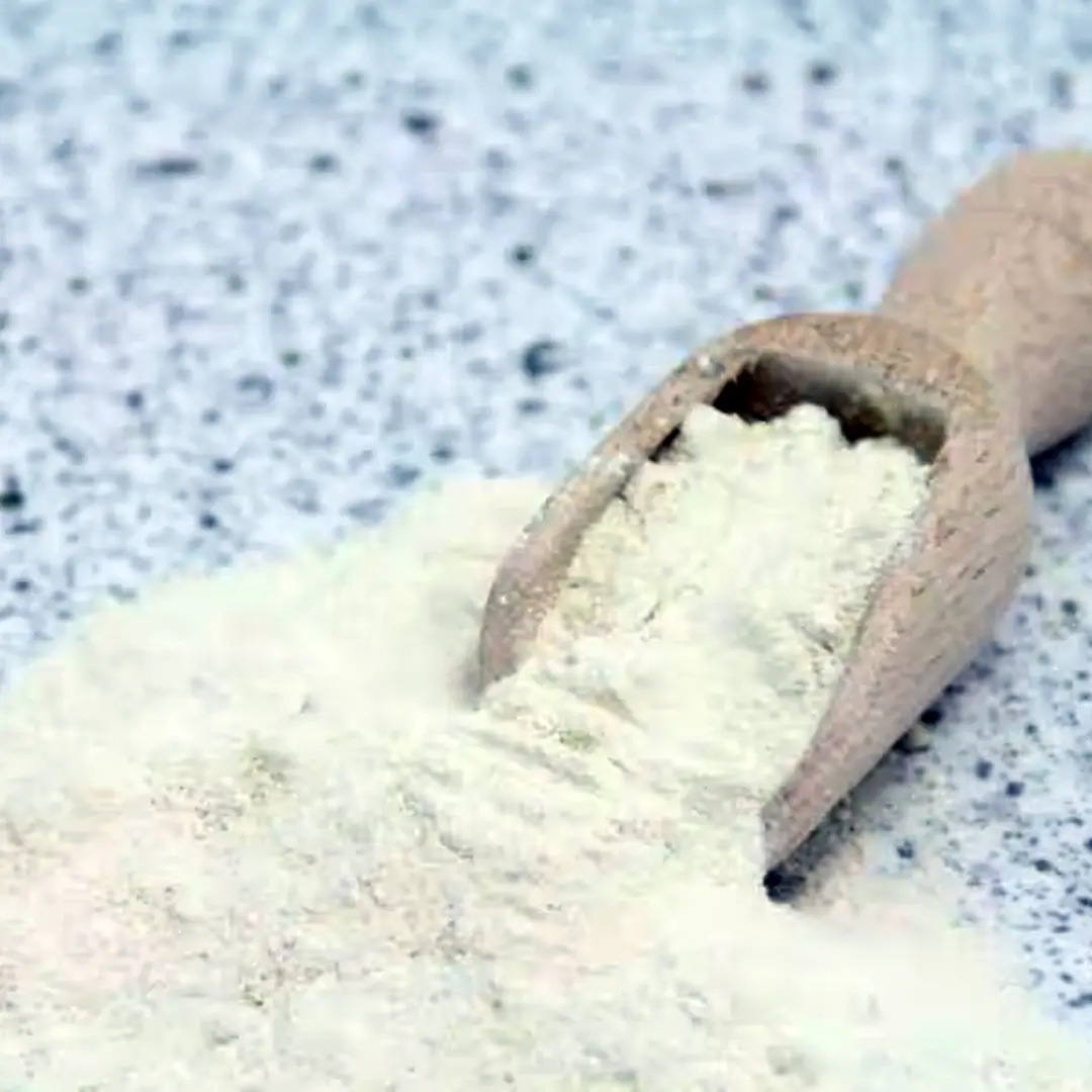 Træske med hvidt mel spredt på en lysegrå, plettet overflade