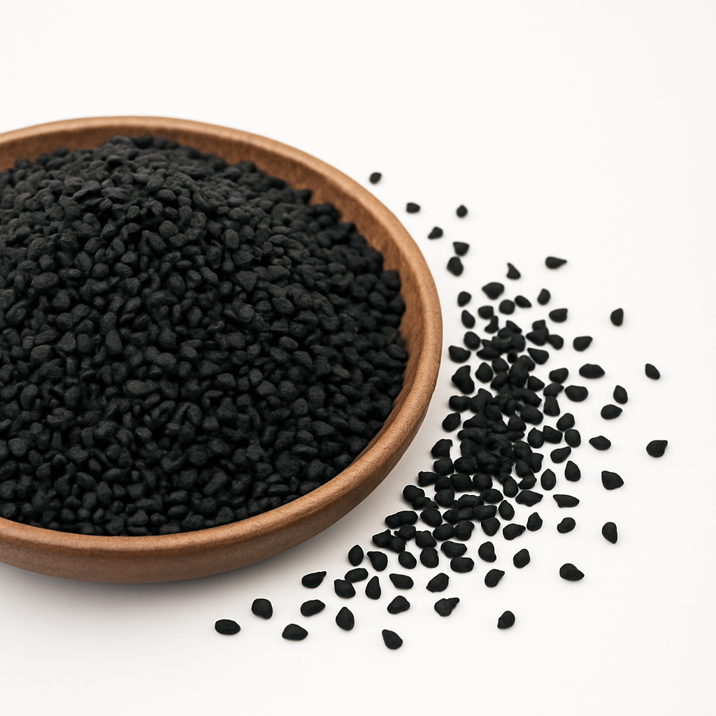 Træskål fyldt med sorte nigellafrø på hvid baggrund, med nogle frø spredt ved siden af