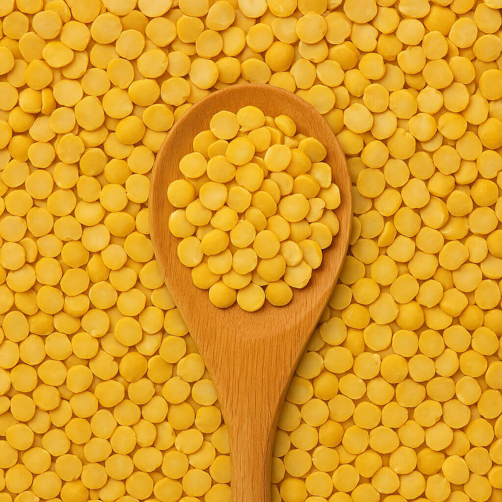 Close-up of yellow split peas in wooden spoon