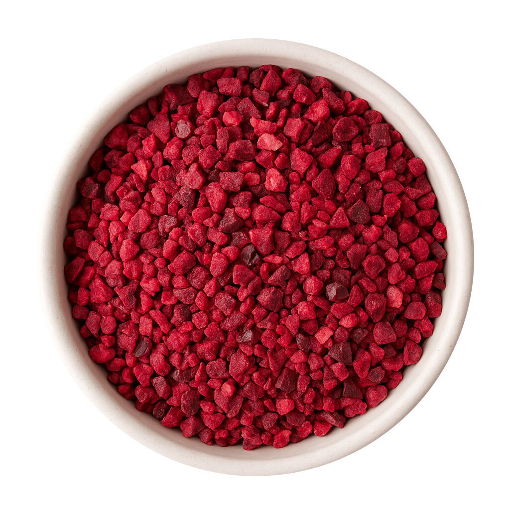 Top view of red fruit granules in white bowl