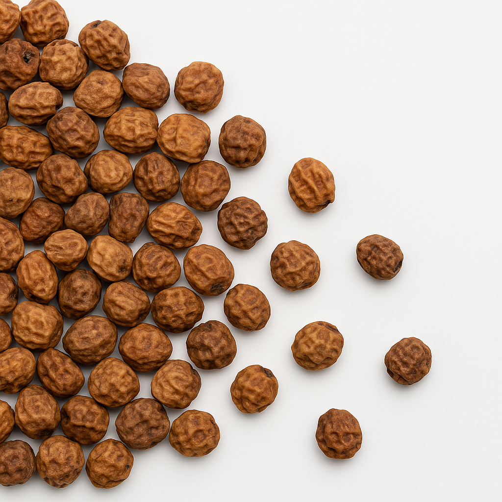 A scattered pile of dried chickpeas on a white surface, showcasing their texture.