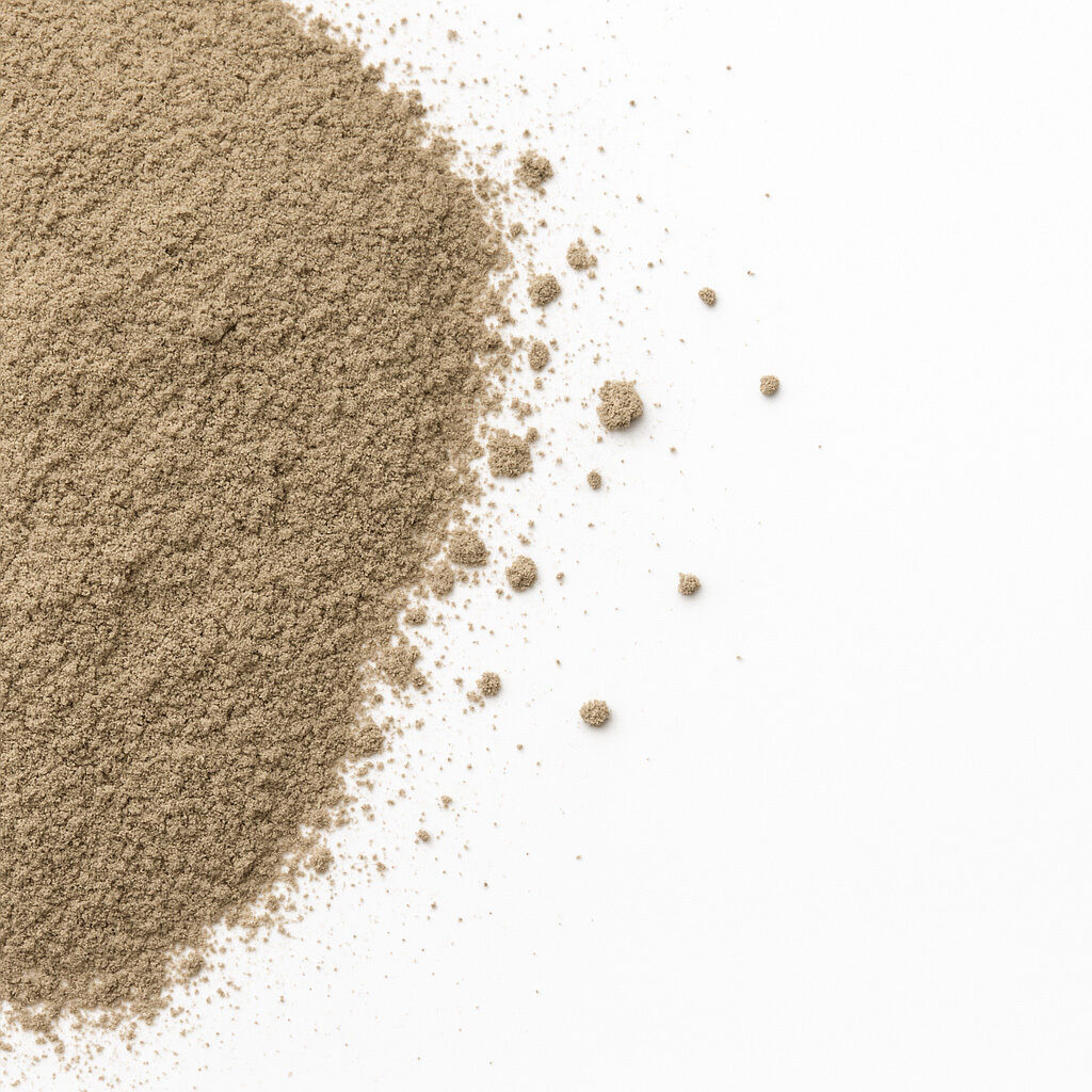 Nærbillede af lysebrunt, fint sand spredt på hvid baggrund med små korn og klumper