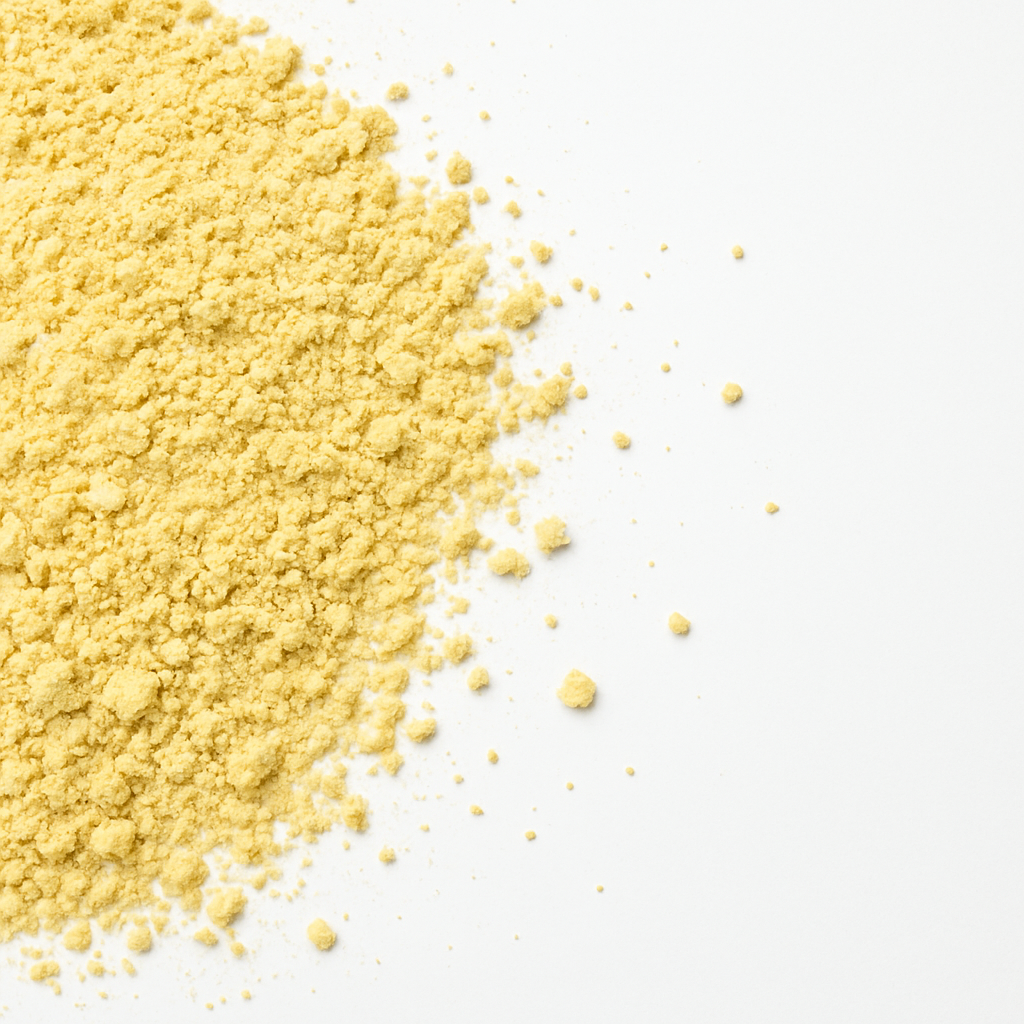 A pile of organic yellow corn flour on a white background
